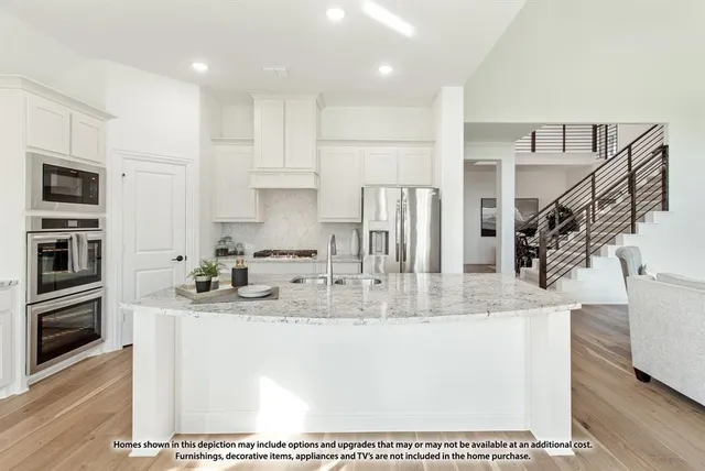 a kitchen with stainless steel appliances granite countertop a sink a stove and a refrigerator