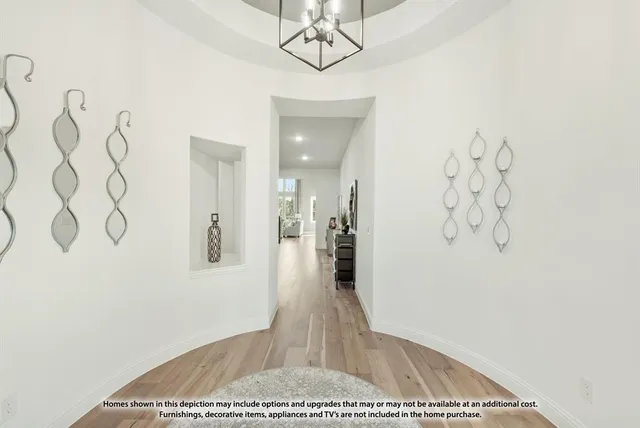 a view of a hallway with wooden floor and chandelier