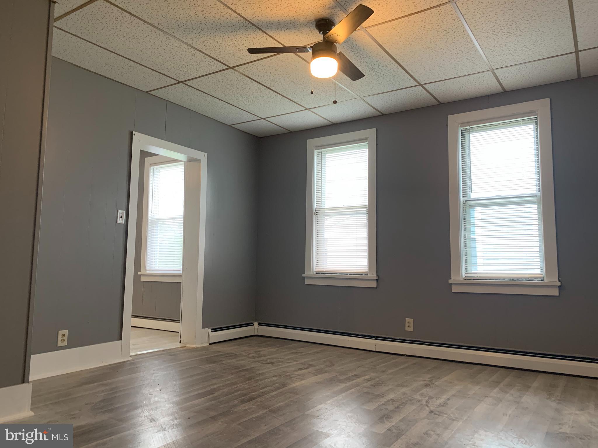 822 Columbus Road Burlington, NJ 08016 - Photo 15 of 32 an empty room with wooden floor fan and windows