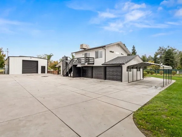a view of a house with backyard and a tree