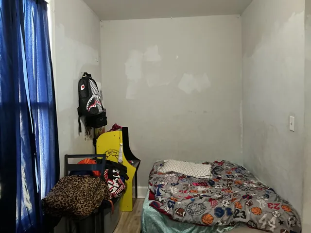 a bed room with a bed and a lamp on dresser