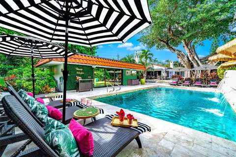 a view of a patio with table and chairs potted plants and palm trees