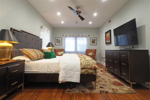a bedroom with a large bed and a painting on the wall