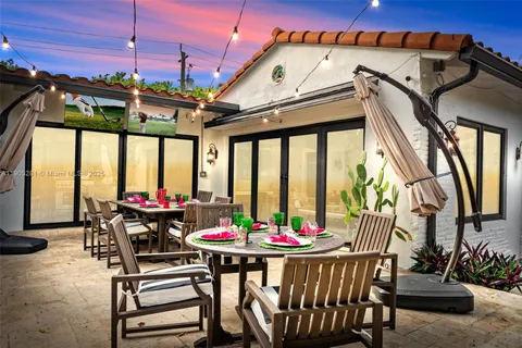 a backyard with table and chairs with a potted plants
