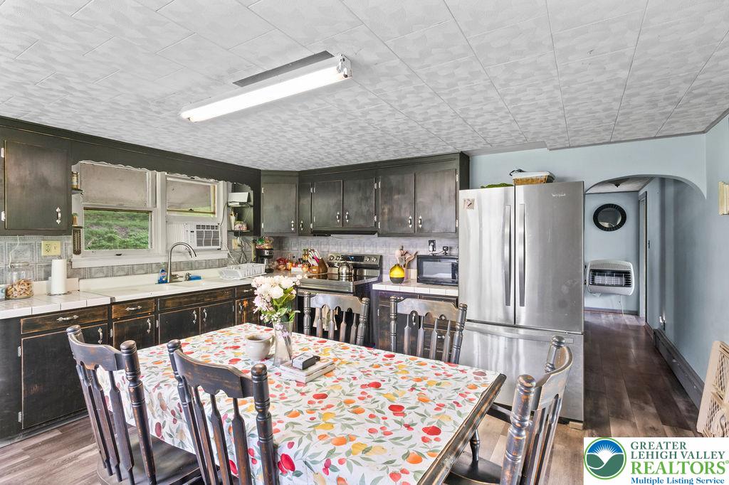 1644 Moselem Spring Road Hamburg, PA 19526 - Photo 8 of 24 a kitchen with stainless steel appliances kitchen island granite countertop a refrigerator a sink a stove a dining table and chairs