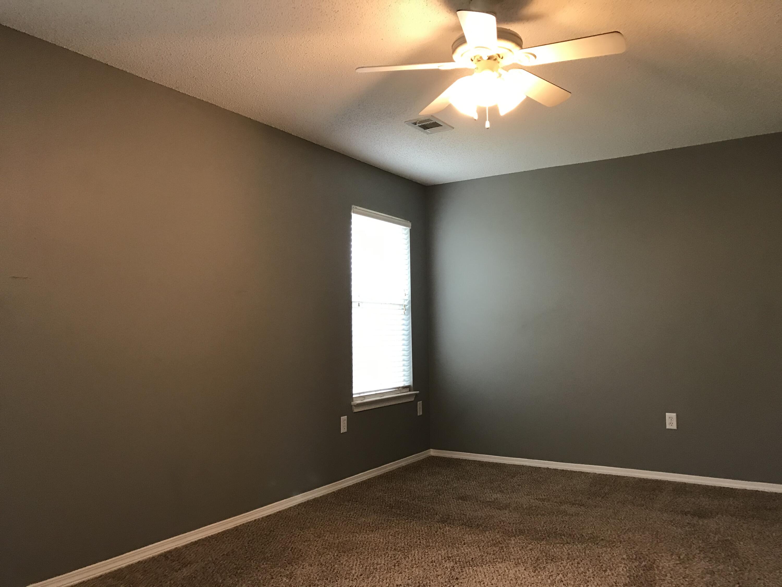 804 Travis Court Crestview, FL 32536 - Photo 18 of 33 an empty room with a window and a fan