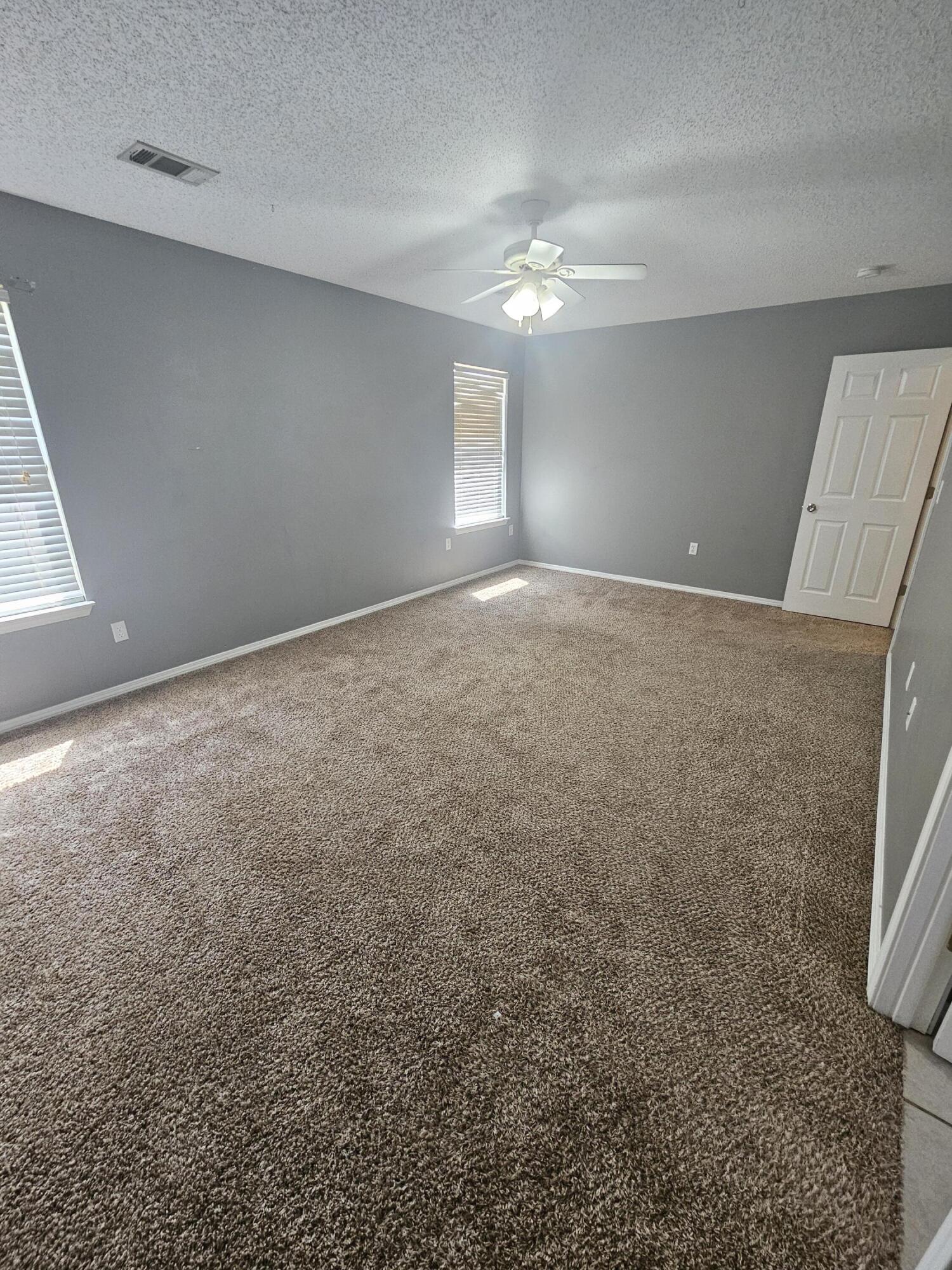 804 Travis Court Crestview, FL 32536 - Photo 27 of 33 en empty room with windows and entrance