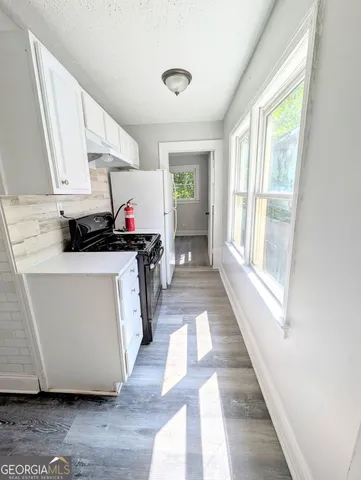 a kitchen with stainless steel appliances a sink a stove a refrigerator a window