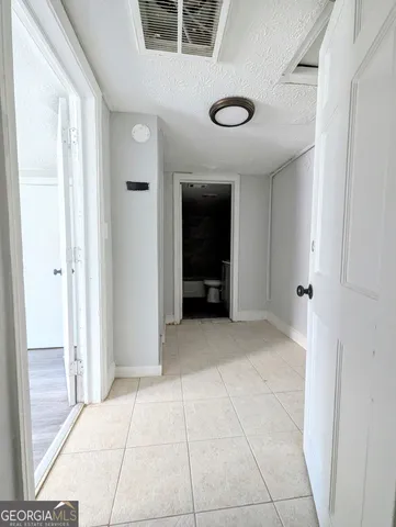 a view of an empty room with closet and a window