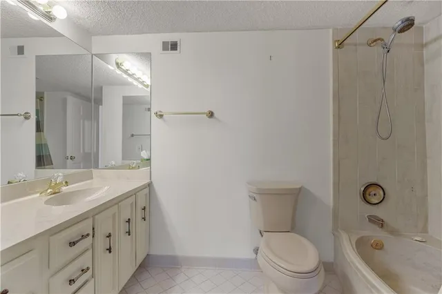a bathroom with a granite countertop sink a toilet and shower