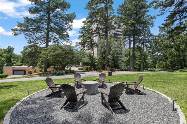a view of a patio with table and chairs potted plants with large tree