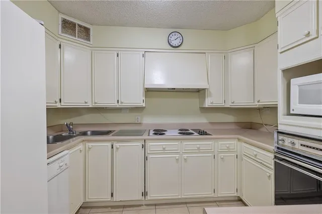 a kitchen with white cabinets and white appliances