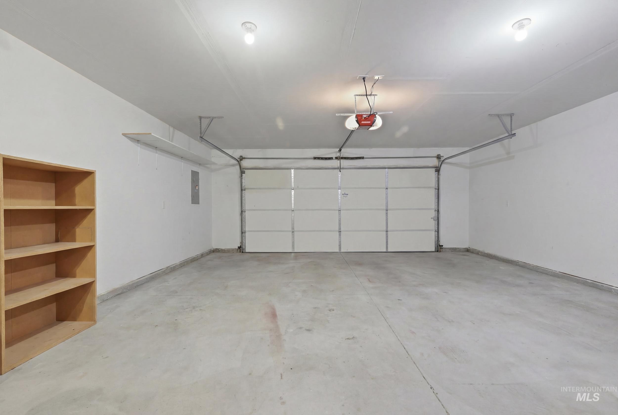 4855 South Chex Way Boise, ID 83709 - Photo 39 of 47 Spacious garage featuring a concrete floor, overhead lighting, and an automatic garage door opener