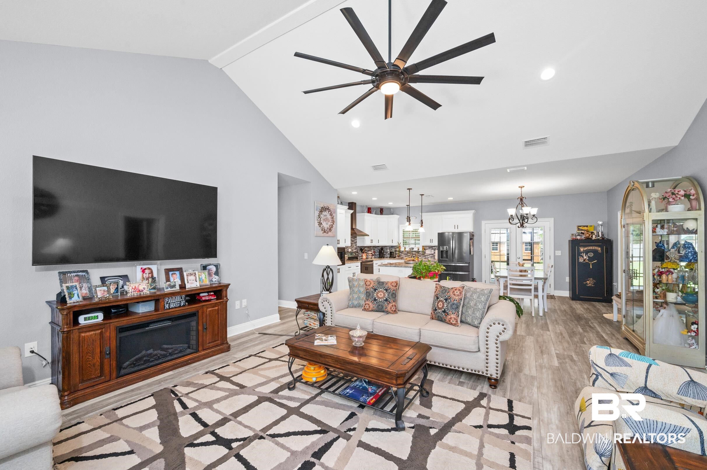 1700 South Juniper Street Foley, AL 36535 - Photo 9 of 51 Living room with ceiling fan with notable chandelier, light hardwood / wood-style floors, and high vaulted ceiling