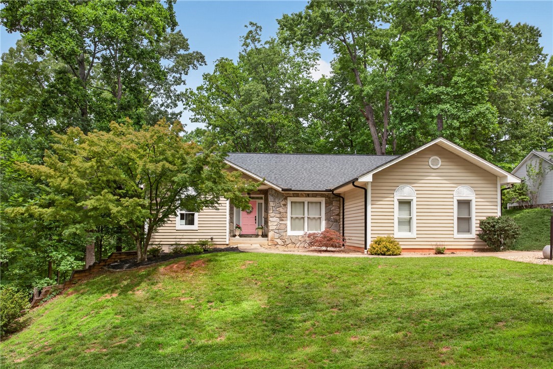 136 Loran Pointe Circle Seneca, SC 29672 - Photo 1 of 50 A charming exterior with stone accents and a vibrant front door nestled into a verdant landscape.