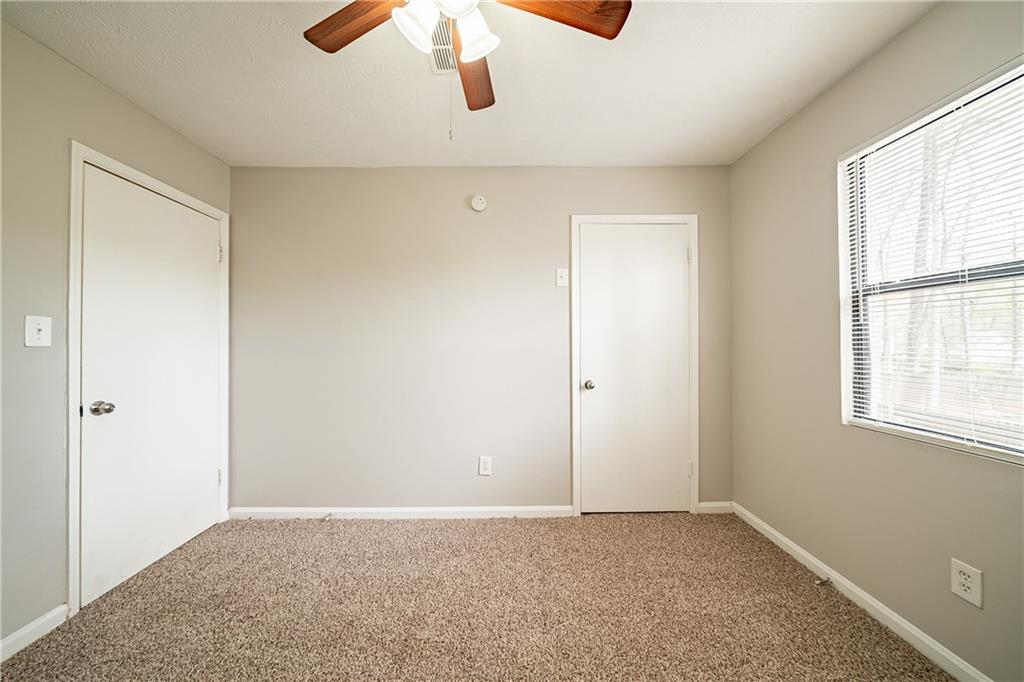 5175 Walker Road Stone Mountain, GA 30088 - Photo 22 of 37 an empty room with a window and chandelier fan