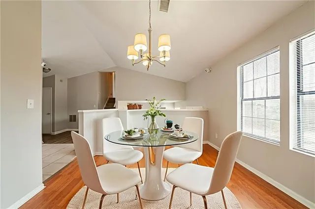 a dining room with furniture a chandelier and wooden floor