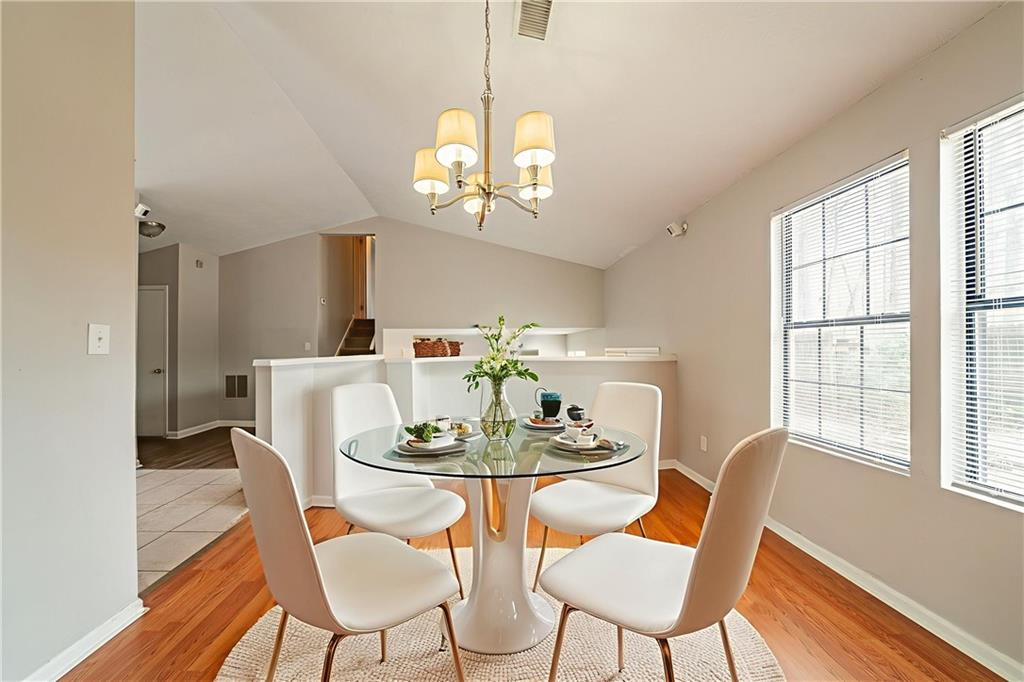 5175 Walker Road Stone Mountain, GA 30088 - Photo 3 of 37 a dining room with furniture a chandelier and wooden floor