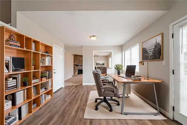 a view of a workspace with furniture and wooden floor