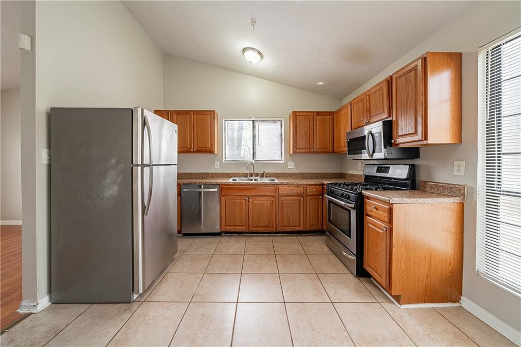 5175 Walker Road Stone Mountain, GA 30088 - Photo 7 of 37 a kitchen with stainless steel appliances granite countertop a refrigerator sink and cabinets