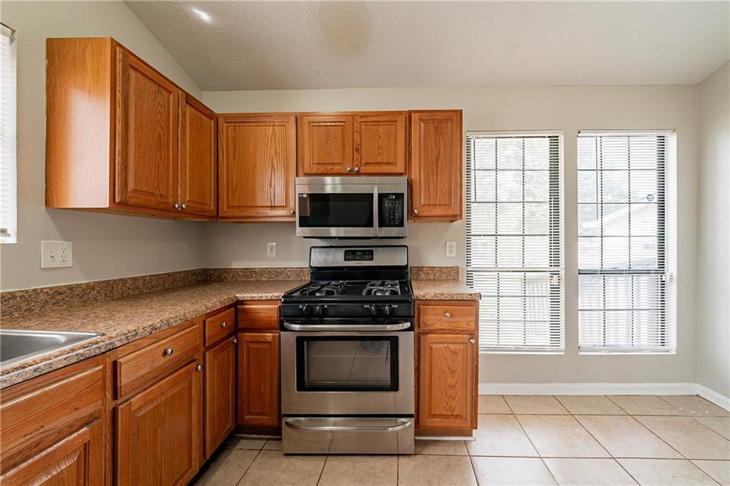 5175 Walker Road Stone Mountain, GA 30088 - Photo 10 of 37 a kitchen with granite countertop a stove top oven microwave and cabinets