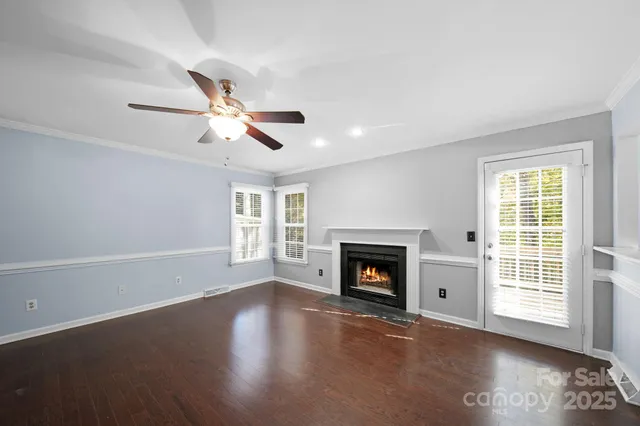 a living room with fireplace and wooden floor