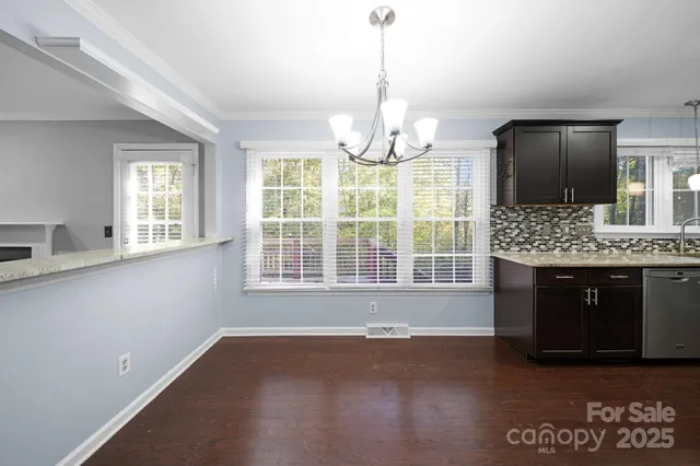 a view of livingroom with kitchen island stainless steel appliances wooden floor and window