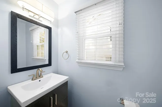 a bathroom with a sink a mirror and a window