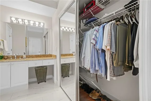 a view of walk in closet with clothes and shoes