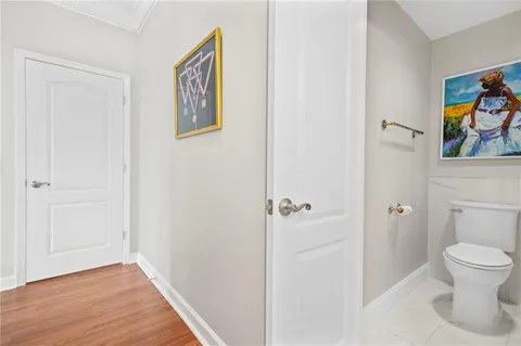 a bathroom with a toilet and a painting on the wall