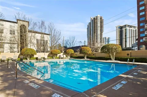 a view of a swimming pool with a patio and plants