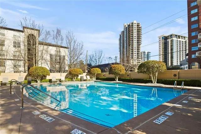 a view of a swimming pool with a patio and plants