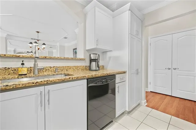 a kitchen with stainless steel appliances granite countertop a sink and dishwasher with white cabinets