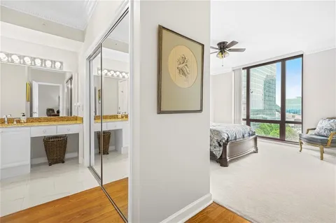 a living room with furniture a large window and wooden floor