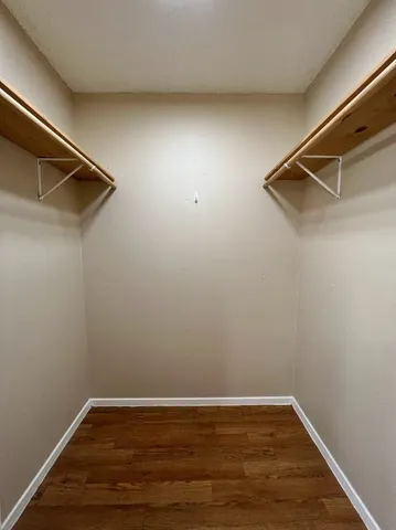 a view of a room with wooden floor and small window