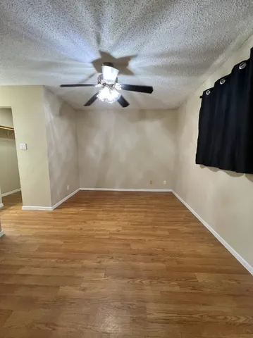 a view of an empty room with wooden floor