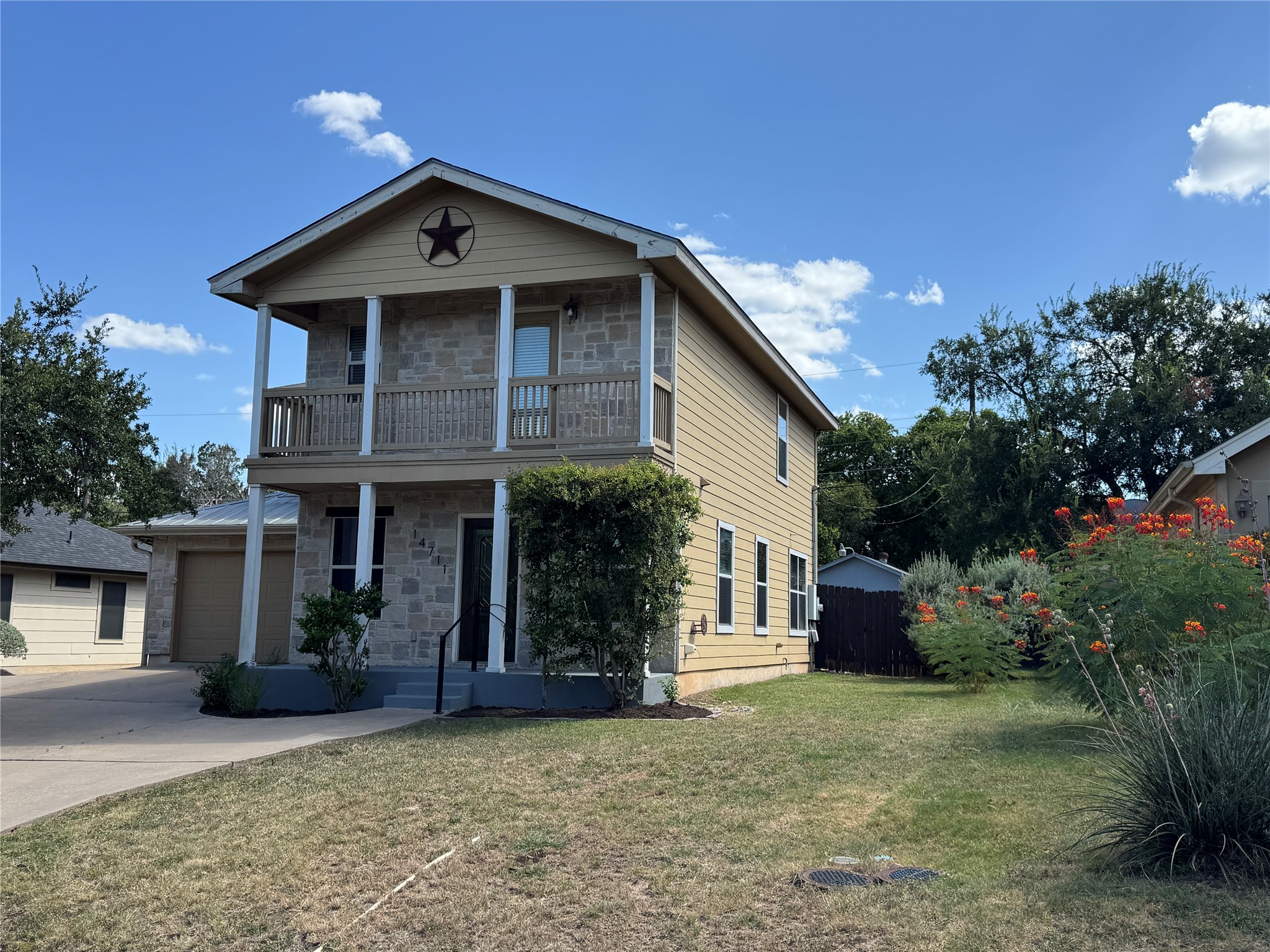 14711 Little Fox Trail Austin, TX 78734 - Photo 2 of 26 Two-story home with a covered front porch and balcony, set on a verdant lot.