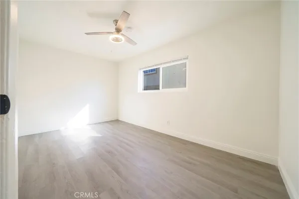 a view of a room with wooden floor and a ceiling fan