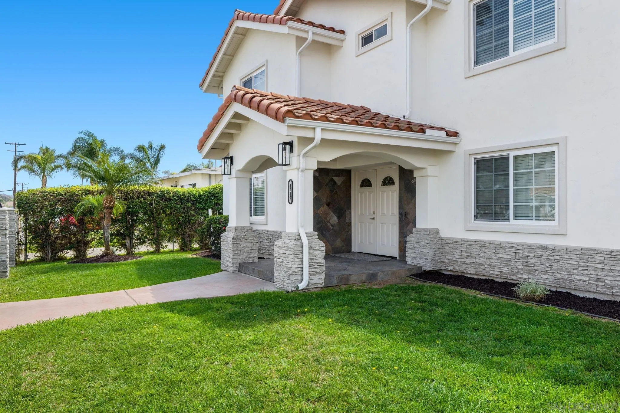 1749-51 Dahlia Avenue San Diego, CA 92154 - Photo 2 of 23 a view of a house with brick walls and a yard with a large tree
