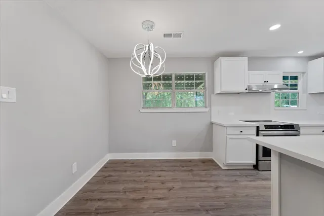 a kitchen with a stove and white cabinets