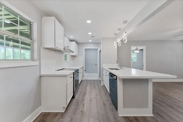 a kitchen with kitchen island a sink stove and wooden floor