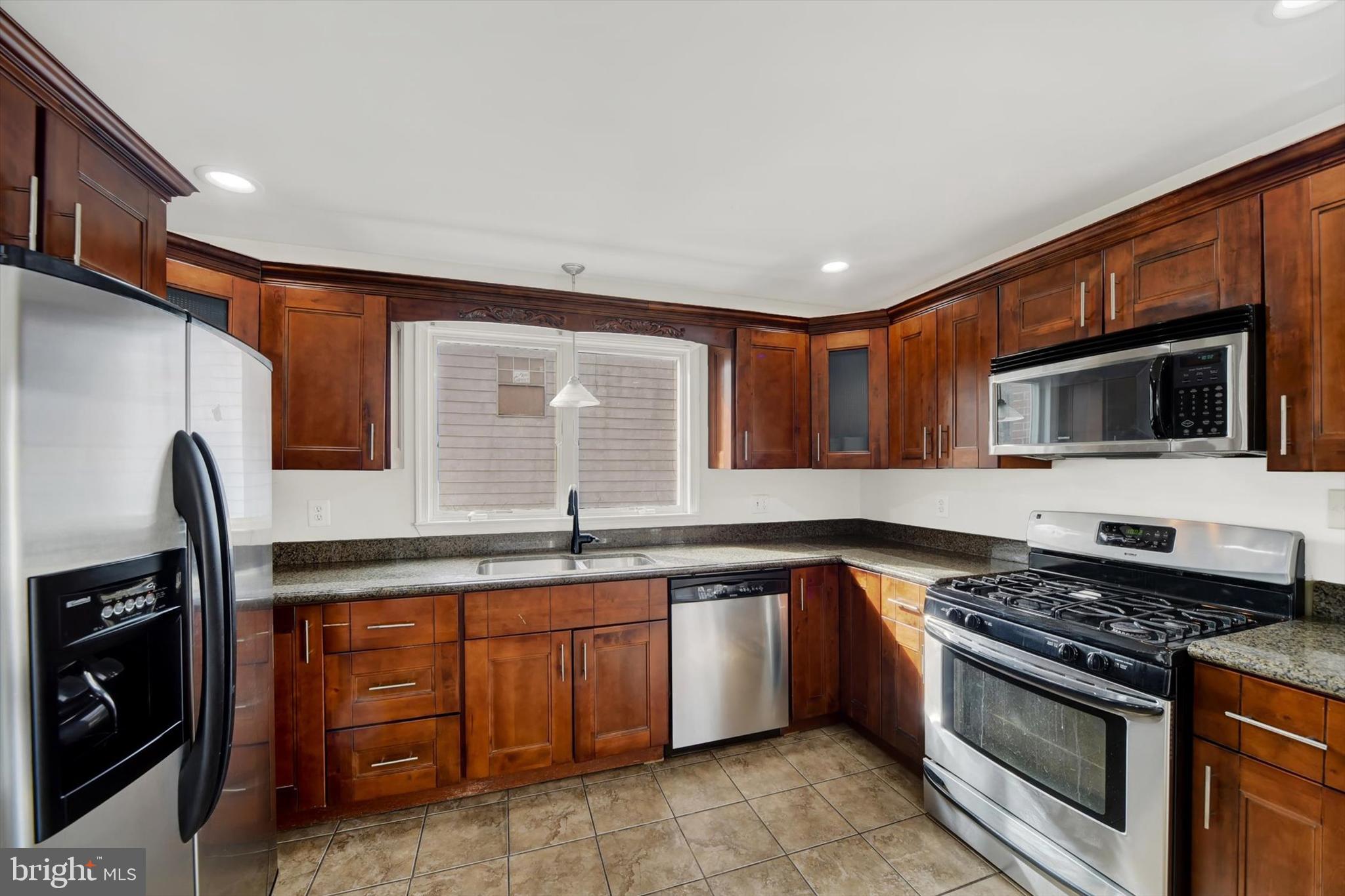 404 Homewood Road Linthicum Heights, MD 21090 - Photo 12 of 24 a kitchen with stainless steel appliances granite countertop a stove a sink and a microwave