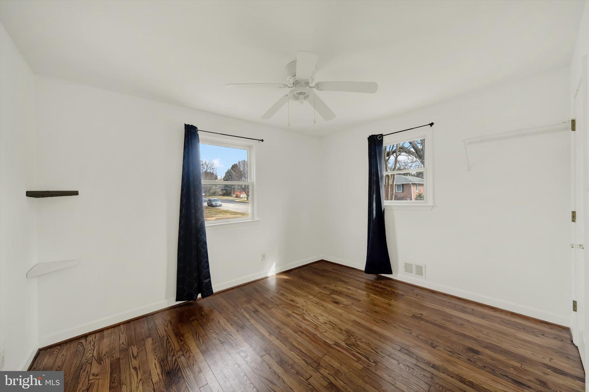 404 Homewood Road Linthicum Heights, MD 21090 - Photo 17 of 24 an empty room with wooden floor chandelier fan and windows