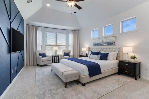 a spacious bedroom with a bed and a flat screen tv