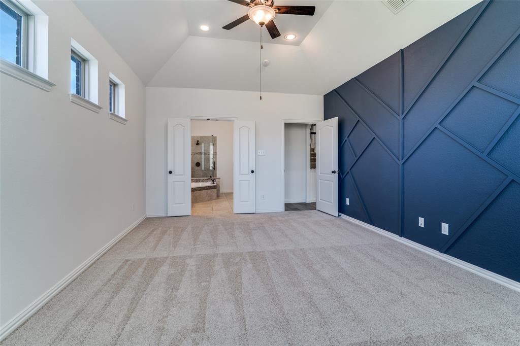 1215 Hundgate Way Forney, TX 75126 - Photo 17 of 38 Another view of the primary bedroom showing entry to the primary bathroom andfeature wall