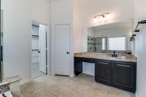 a spacious bathroom with a granite countertop sink two mirror and a
