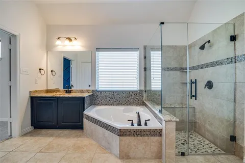a spacious bathroom with a tub a sink and mirror