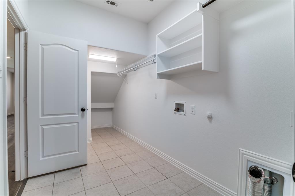 1215 Hundgate Way Forney, TX 75126 - Photo 22 of 38 Laundry room withdryer hookup, washer hookup, and light tile patterned floors with extra space under the stairs