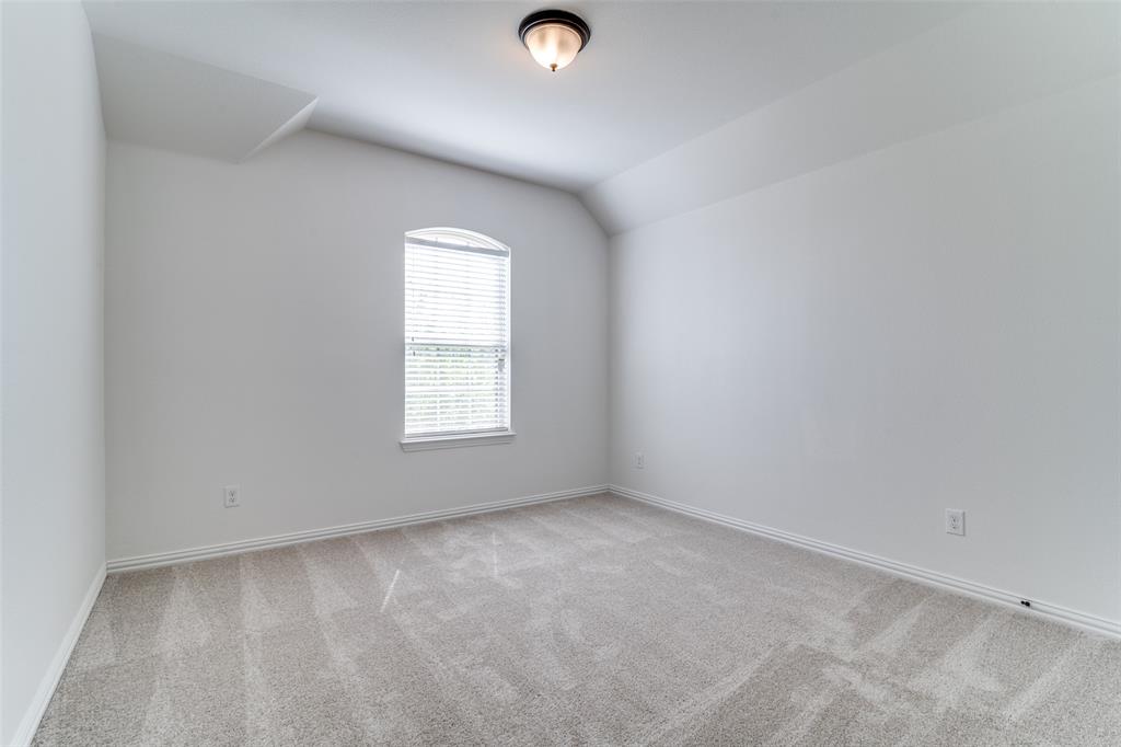 1215 Hundgate Way Forney, TX 75126 - Photo 28 of 38 Upstairs bedroom #2 with light colored carpet and vaulted ceiling