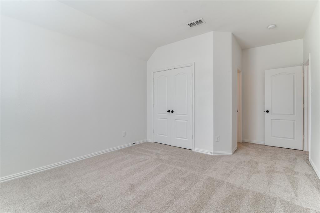 1215 Hundgate Way Forney, TX 75126 - Photo 29 of 38 Upatairs bedroom #2 featuring light colored carpet, a closet, and lofted ceiling with ensuite bathroom